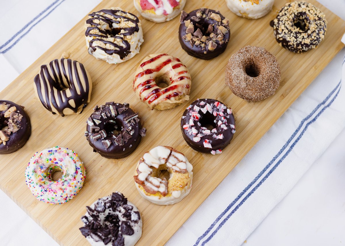 An assortment of donuts that we offer on a wooden cutting board