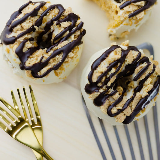 Cheesecake Crumble Donuts next to forks & a spatula