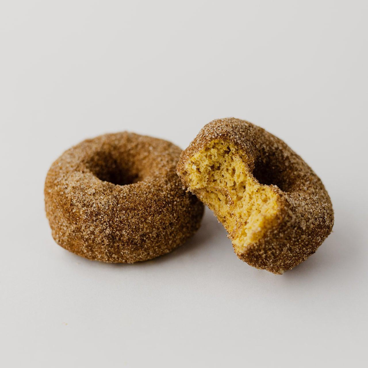 2 Cinnamon Sugar Donuts, 1 has a bite taken out of it