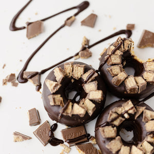 3 Kit Kat Protein Donuts with chocolate drizzled on them