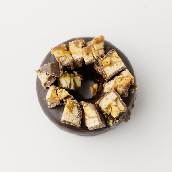 A Snickers Protein Donut on a white background